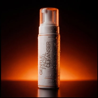 ASCEND Gentle Facial Cleanser bottle with water droplets against a dark, orange-lit background.